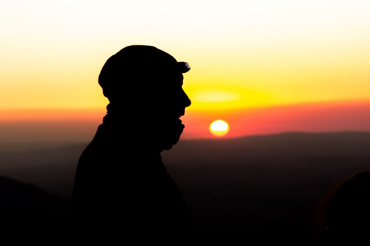 Silhouette of a hiker on a volcano trail at first light