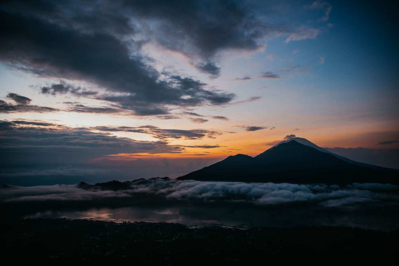 Mount Batur silhouette above low clouds, the best time for a sunrise jeep tour