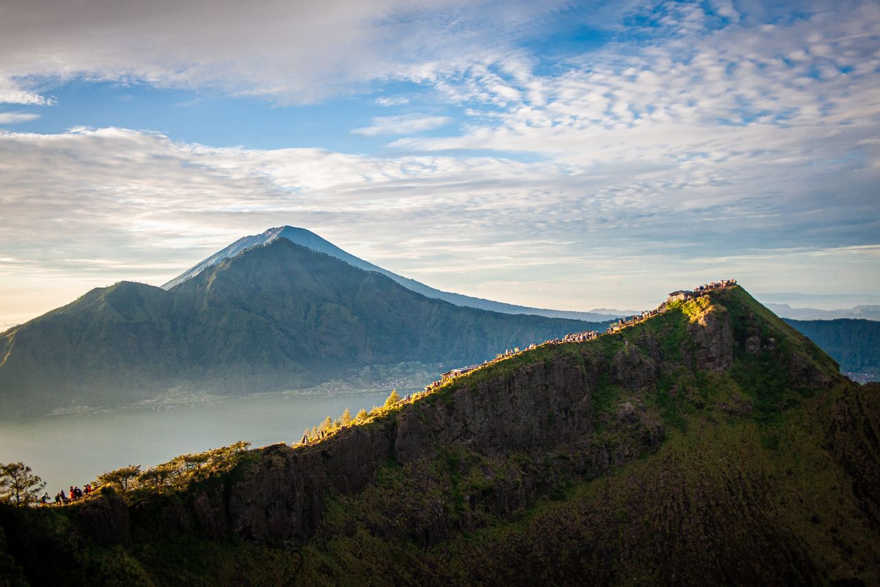 Tourists watching the Mount Batur sunrise from a viewpoint in Bali